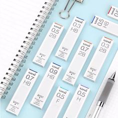 an assortment of medical supplies on top of a blue table next to a notepad and pen