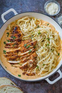 chicken parmesan in a skillet with bread on the side