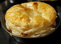 a baked pastry sitting on top of a metal pan next to a black countertop