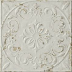 an old white square tile with ornate designs