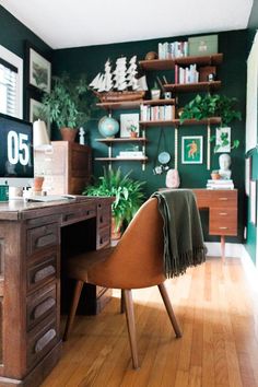 a home office with green walls and wooden floors