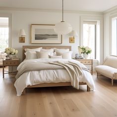 a large white bed sitting in a bedroom on top of a hard wood floor