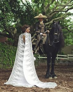 a woman in a wedding dress standing next to a man on a horse wearing a sombrero