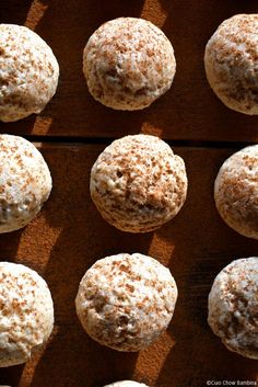 several muffins sitting on top of a wooden table covered in powdered sugar