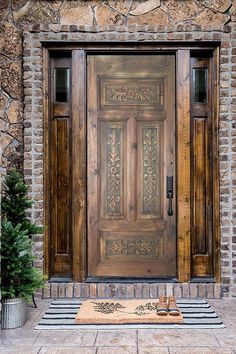 a wooden door sitting on the side of a stone building next to a potted plant