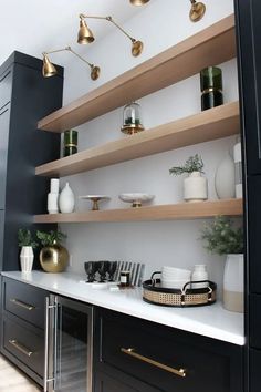 the shelves in this kitchen are lined with gold and white dishes, vases, and other decorative items