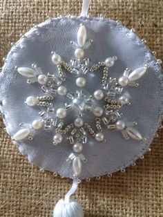 an ornament with pearls and tassels on a burlocked surface