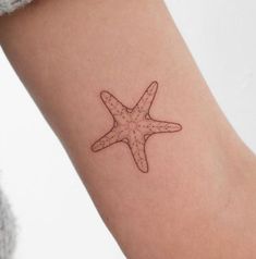 a small starfish tattoo on the right arm is shown in black and grey ink