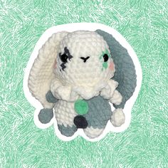 a crocheted stuffed animal sitting on top of a green and white pattern background