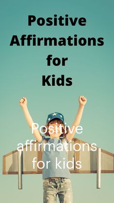 a young boy standing on top of a wooden bench with his arms in the air