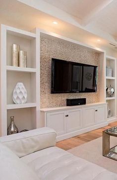 a living room filled with furniture and a flat screen tv mounted on a wall above a fireplace