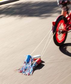 a motorcyclist is pulling an object down the street with his bike behind him