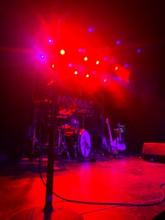 the stage is lit up with red and blue lights as well as musical instruments on it