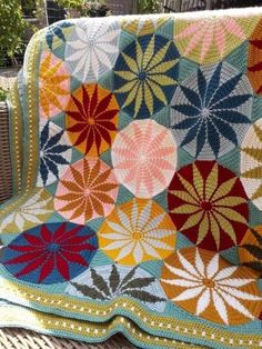 a crocheted blanket is sitting on a chair