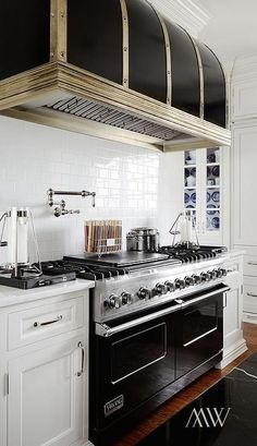 a stove top oven sitting inside of a kitchen next to an oven hood above it