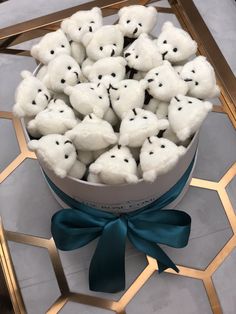 a bucket filled with white teddy bears on top of a table