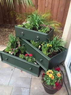 several green planters with flowers in them