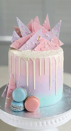 a pink and blue cake with icing dripping from it