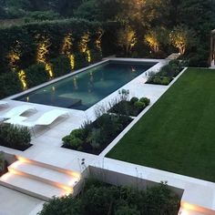 an outdoor garden is lit up at night with lights shining on the grass and steps