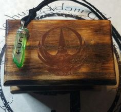 a wooden box with a green bead hanging from it