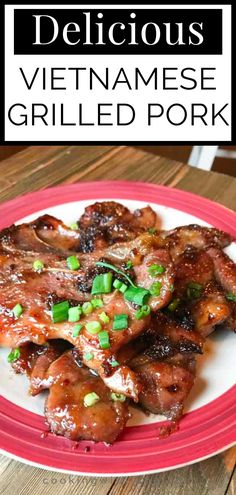 the plate is full of meat with green onions and sauce on it, sitting on a wooden table