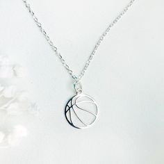 a silver necklace with a basketball on it's side and a ball in the middle