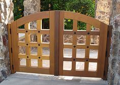 an open wooden gate in front of stone pillars