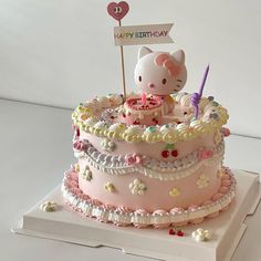 a hello kitty birthday cake on a white table