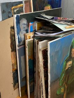 many paintings are stacked on top of each other