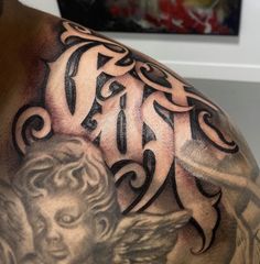 a close up of a man's shoulder with an angel tattoo design on it