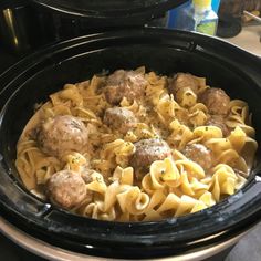 two crock pot filled with pasta and meatballs