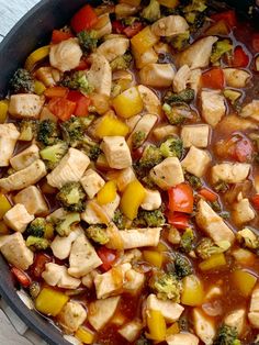 a pan filled with chicken, broccoli and peppers