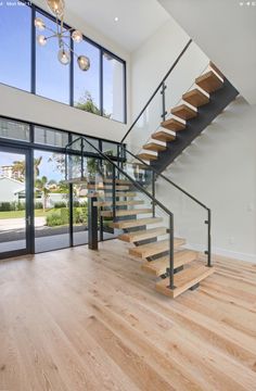 an open floor plan with wood floors and stairs