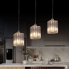 three lights hanging over a kitchen counter top