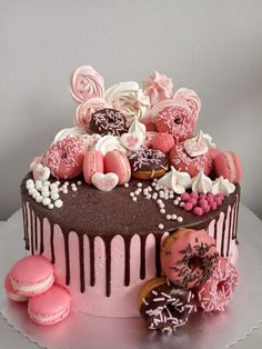 a pink and chocolate decorated cake sitting on top of a table