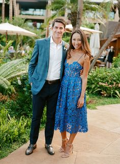 a man standing next to a woman in a blue dress