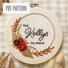 the reely's embroidery pattern is displayed on a table with dried flowers and leaves