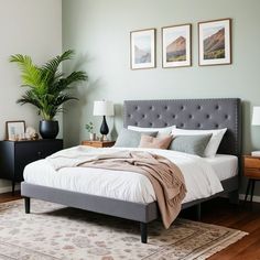 a bedroom with a bed, nightstands and two pictures on the wall above it