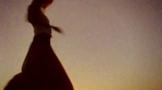 the silhouette of a woman standing on top of a hill