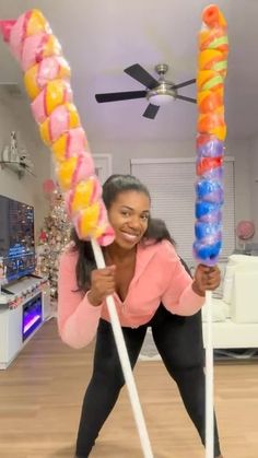 a woman holding two large candy canes in her hands