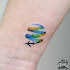 a small colorful bird tattoo on the wrist