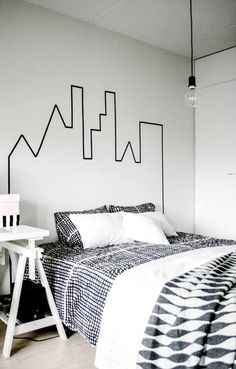 a bed with black and white bedspread in a bedroom next to a table