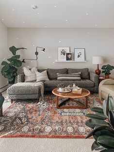 a living room with two couches, a coffee table and some pictures on the wall