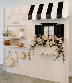 a store front with flowers in the window and shelves on the wall, along with other items