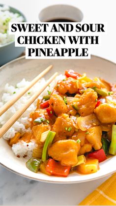 a white plate topped with chicken and veggies next to chopsticks on top of rice