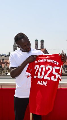 a man holding up a red shirt on top of a roof