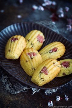 some cookies are on a black plate with pink flowers