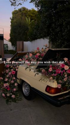 a car with flowers growing out of it's hood that says, love yourself the way you wish they did