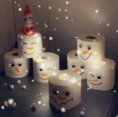 toilet paper snowmen are sitting on the floor in front of some rolls of toilet paper