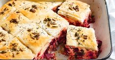 a casserole dish with meat and cheese in it on a white table cloth